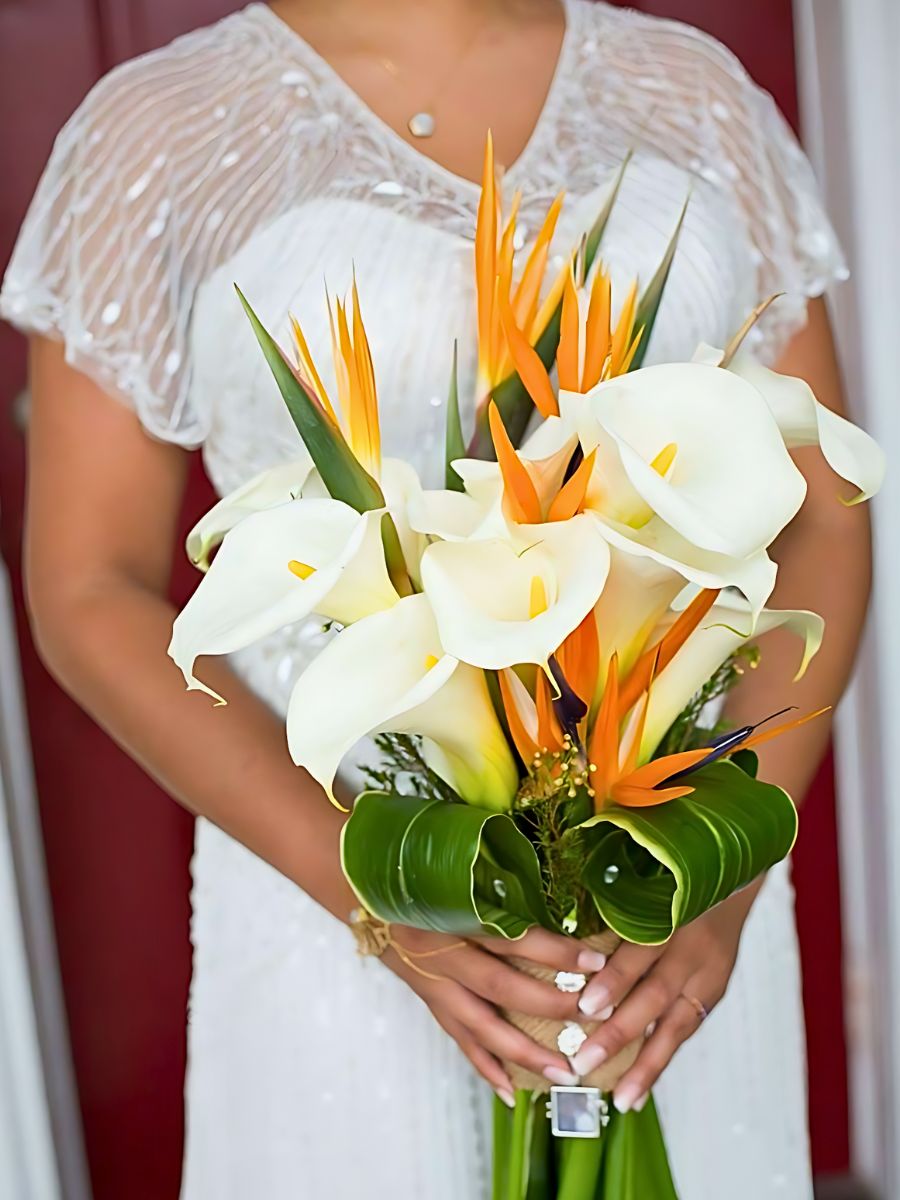 woman holding bouquet made of calla and strelitzia - The bird of paradise (strelitzia) is also one of the birth flowers for Aquarius and is represented here as a floral gift