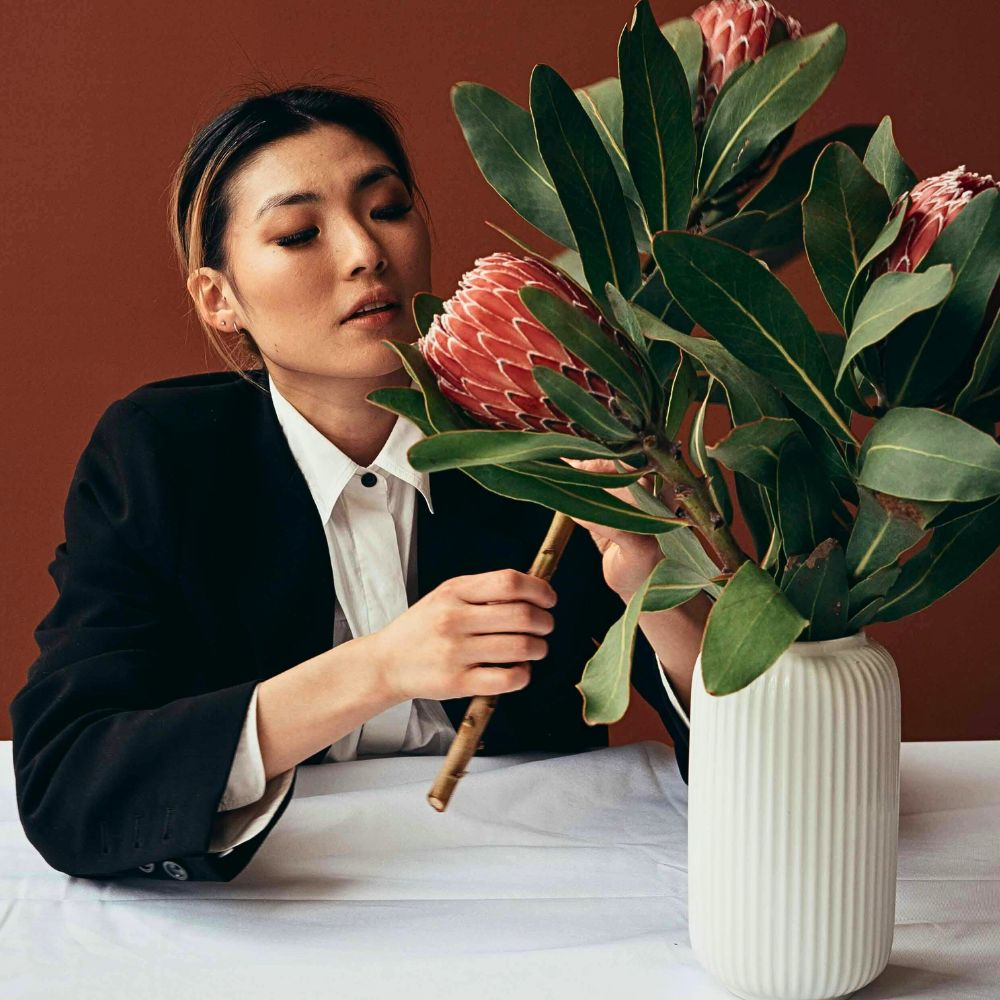 a lady caring for her Protea magnifica kept in a vase