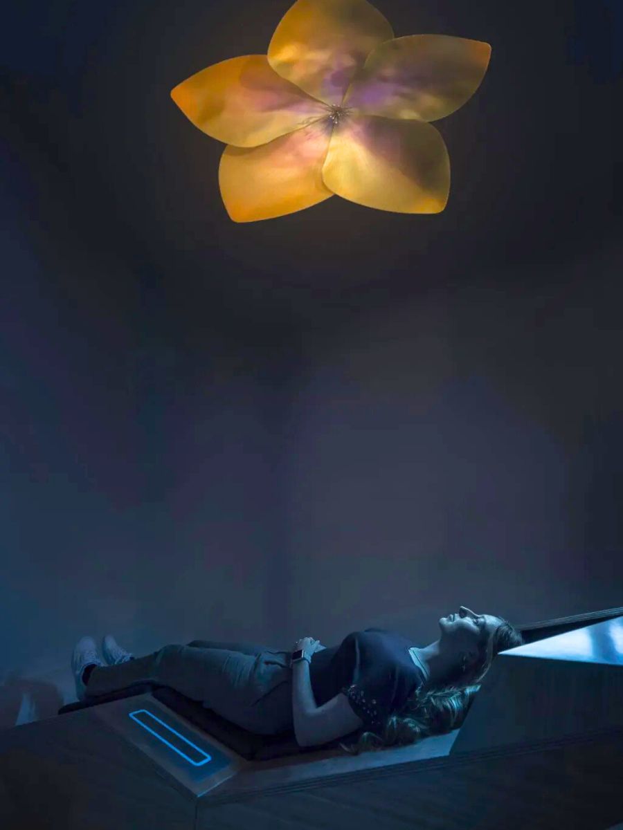 Woman looking up at a digital flower experience