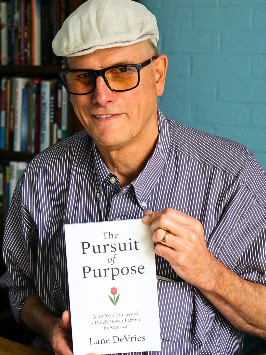 Lane DeVries holding his a copy of his book