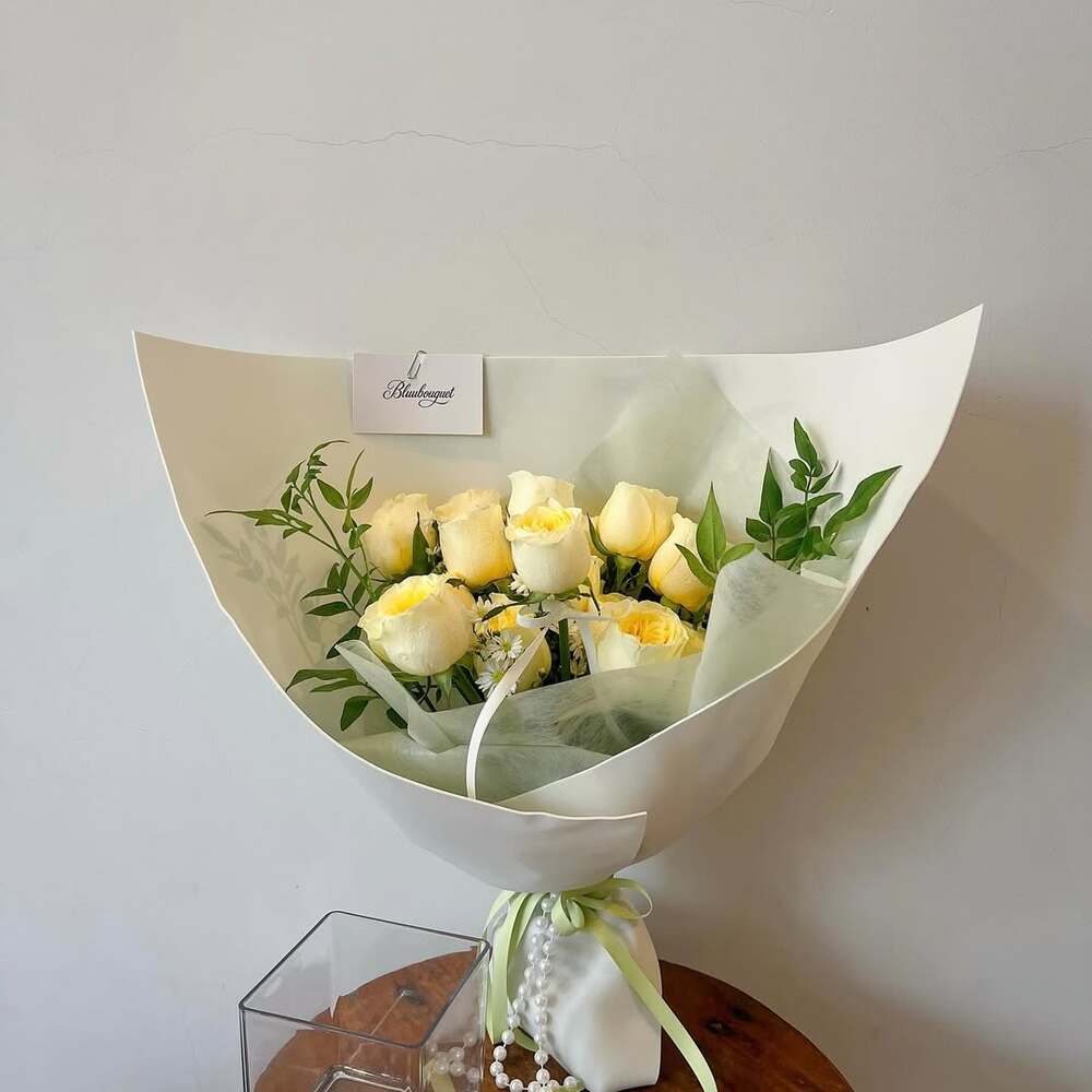  Yellow roses in white paper bouquet