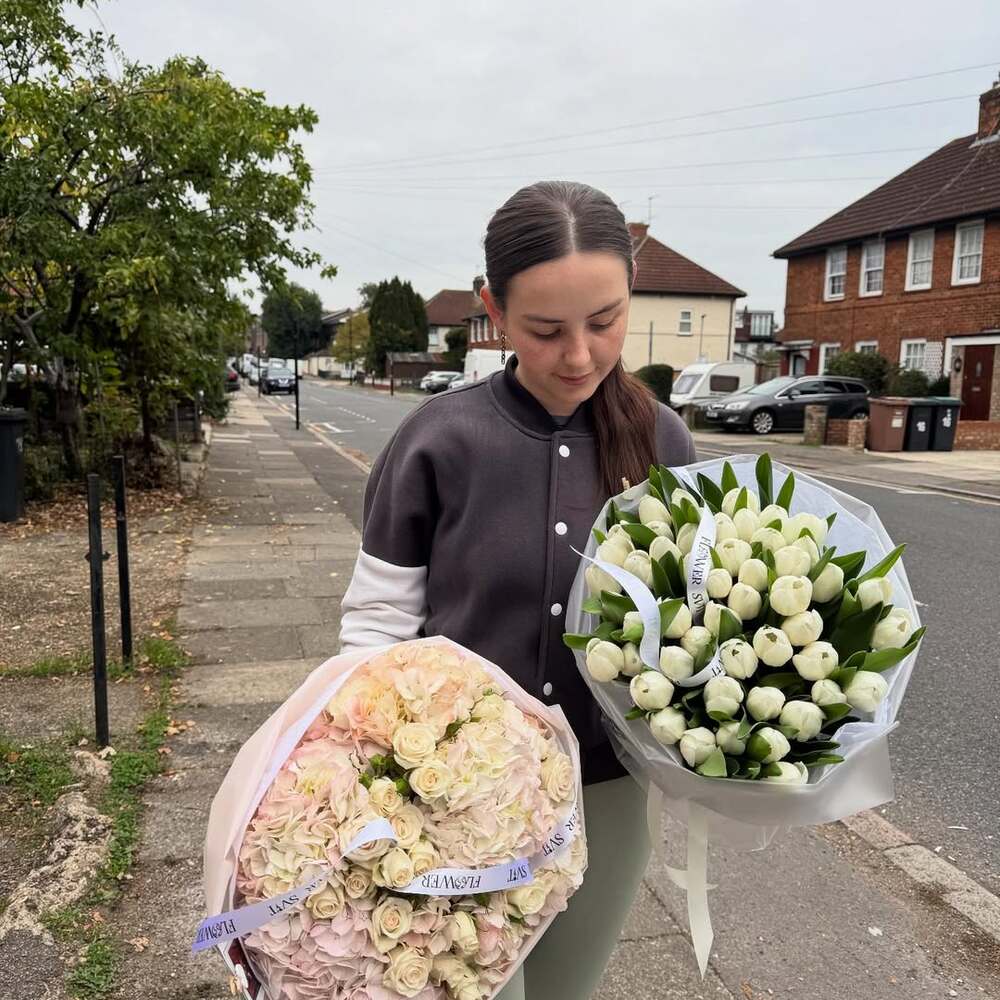 Florist holds two large flower bouquets