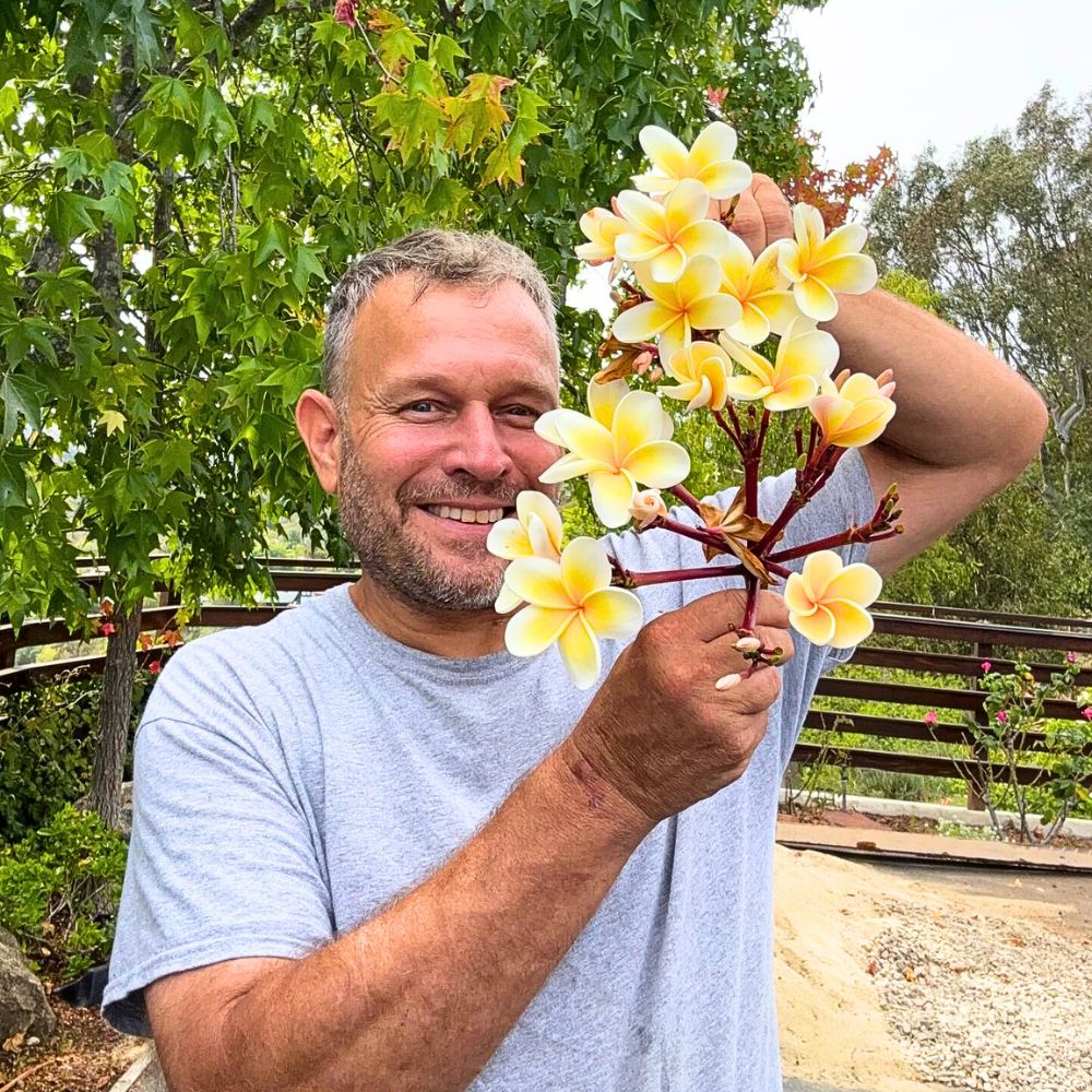 A man holding plumeria flowers